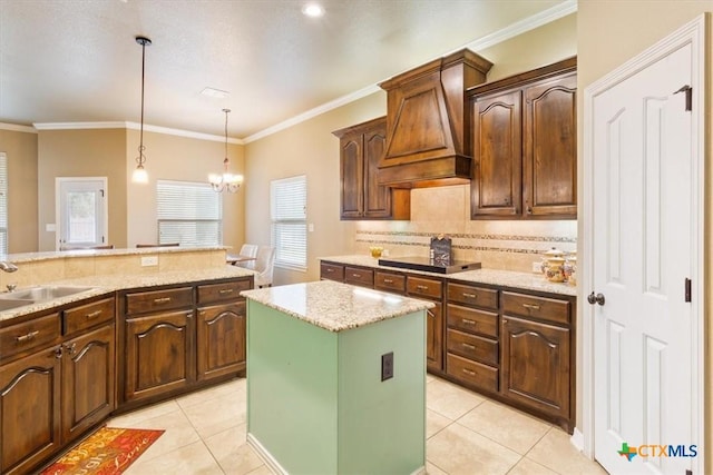 kitchen featuring hanging light fixtures, a kitchen island, sink, black electric stovetop, and light tile patterned flooring