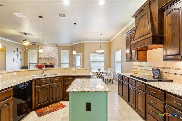 kitchen featuring sink, a kitchen island, black appliances, and light stone counters