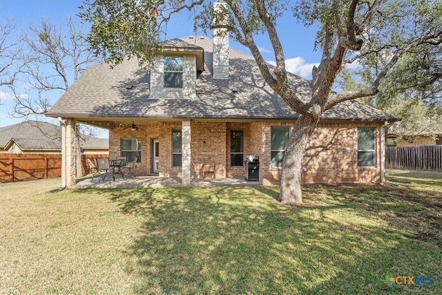 rear view of property featuring a patio, ceiling fan, and a yard