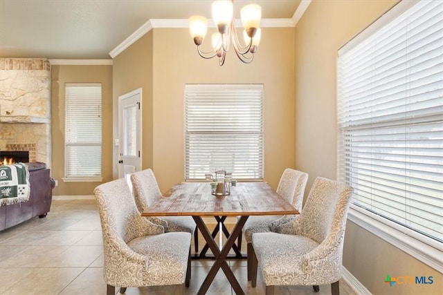 dining room with a fireplace, light tile patterned floors, a chandelier, and crown molding