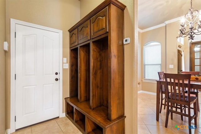 mudroom featuring light tile patterned floors, crown molding, and a notable chandelier