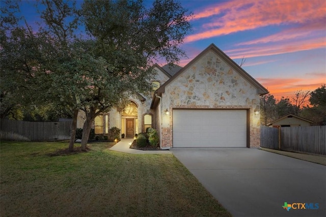 view of front of property featuring a garage and a lawn