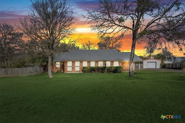 view of front of house with a yard, a garage, and an outdoor structure