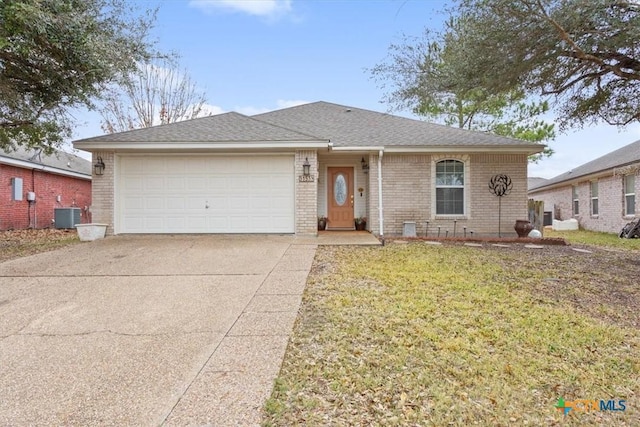 view of front of property with a garage, a front yard, and central air condition unit