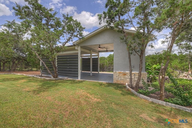 2194 Ranch Loop Dr, New Braunfels, TX 78132 - back of house with ceiling fan, a lawn, stairs, and stucco siding