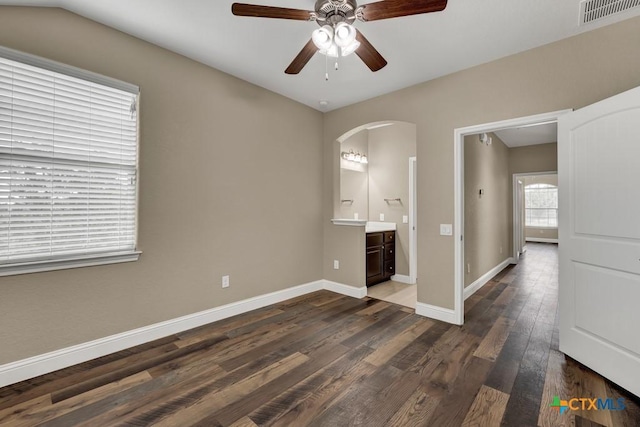2194 Ranch Loop Dr, New Braunfels, TX 78132 - unfurnished bedroom with arched walkways, dark wood-style flooring, ensuite bathroom, and a ceiling fan