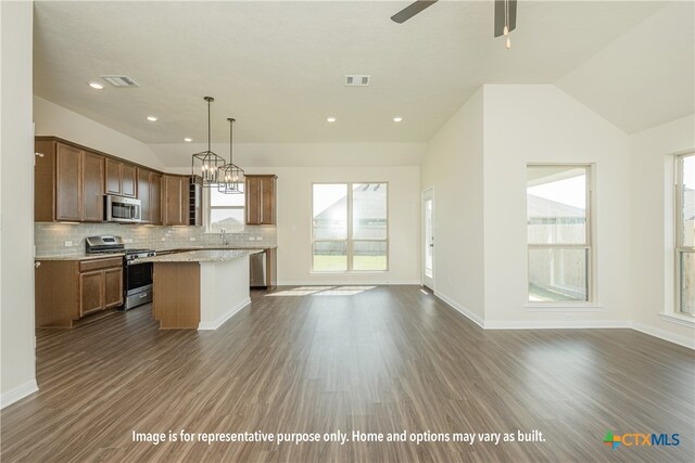 kitchen featuring visible vents, a kitchen island, open floor plan, hanging light fixtures, and stainless steel appliances