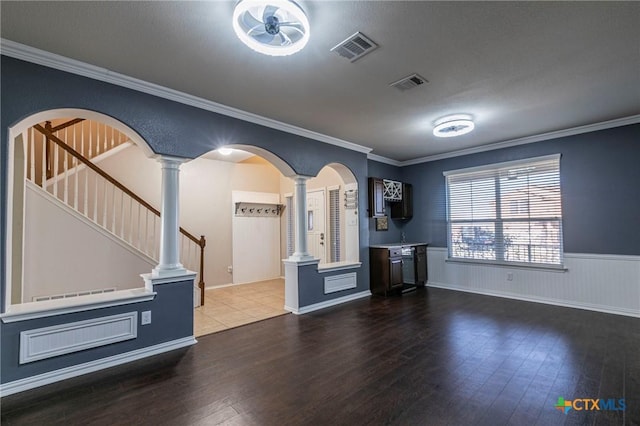 interior space with visible vents, arched walkways, dark wood-style floors, crown molding, and ornate columns