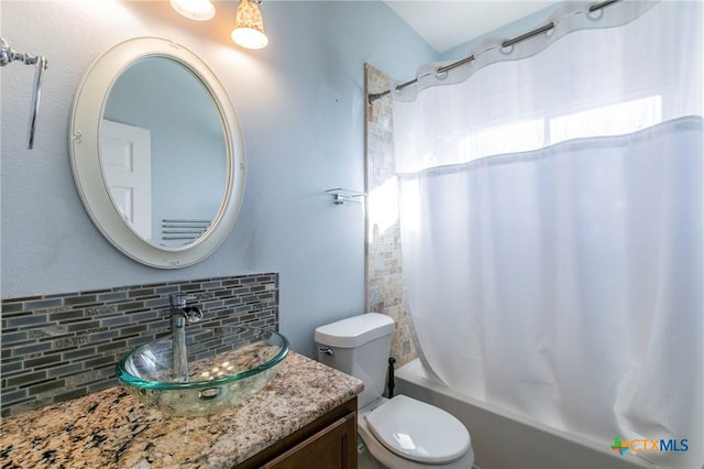 bathroom with tasteful backsplash, vanity, toilet, and shower / tub combo