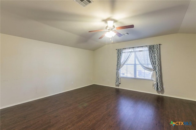 empty room with baseboards, visible vents, ceiling fan, dark wood-type flooring, and vaulted ceiling