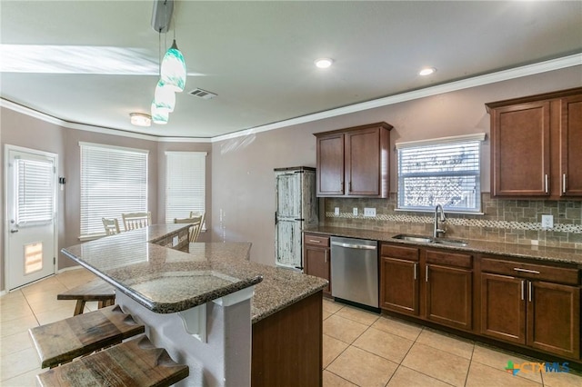 kitchen featuring visible vents, dark stone counters, a center island, stainless steel dishwasher, and a sink