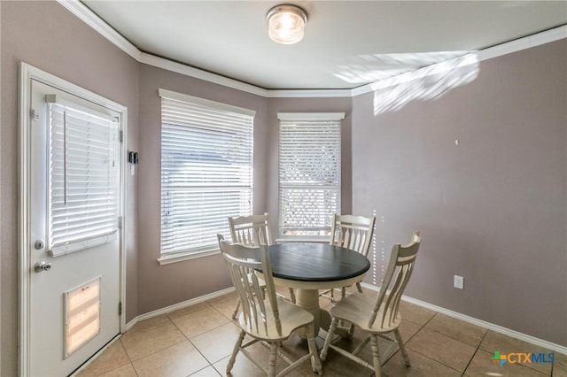 dining space with crown molding, baseboards, and light tile patterned floors