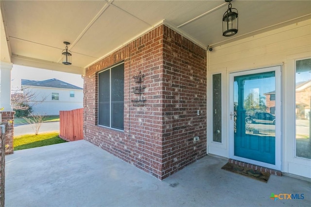 entrance to property featuring brick siding