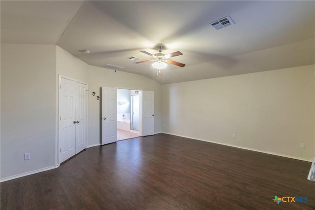 empty room with dark wood-style floors, visible vents, vaulted ceiling, ceiling fan, and baseboards