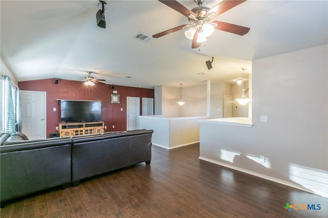 living area with baseboards, visible vents, ceiling fan, dark wood-style flooring, and vaulted ceiling