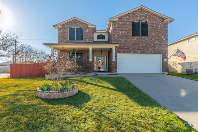 traditional home with driveway, an attached garage, fence, a front yard, and brick siding