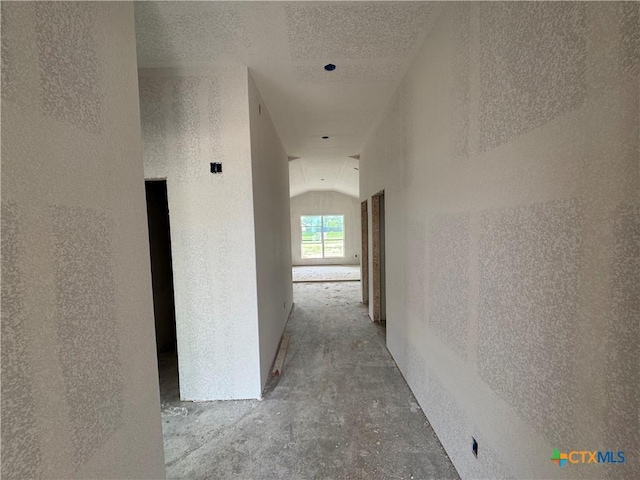 6001 Aquilla Dr, Killeen, TX 76542 - corridor with vaulted ceiling, concrete flooring, and a textured ceiling