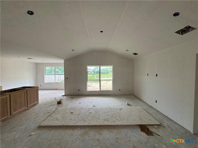 6001 Aquilla Dr, Killeen, TX 76542 - unfurnished living room featuring a textured ceiling and vaulted ceiling