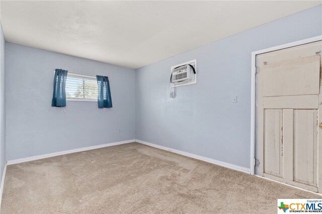 carpeted spare room featuring a wall mounted AC