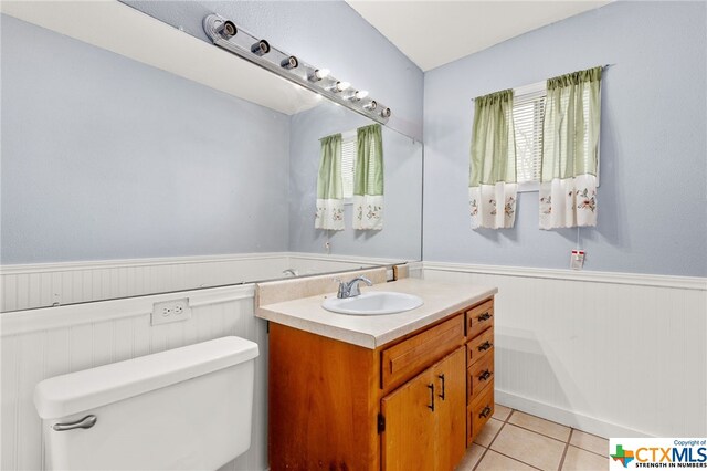 bathroom with toilet, vanity, and tile patterned floors