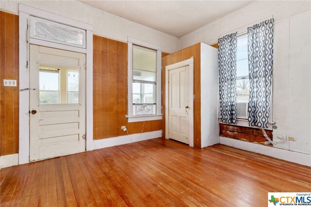 entrance foyer with light hardwood / wood-style floors and wooden walls