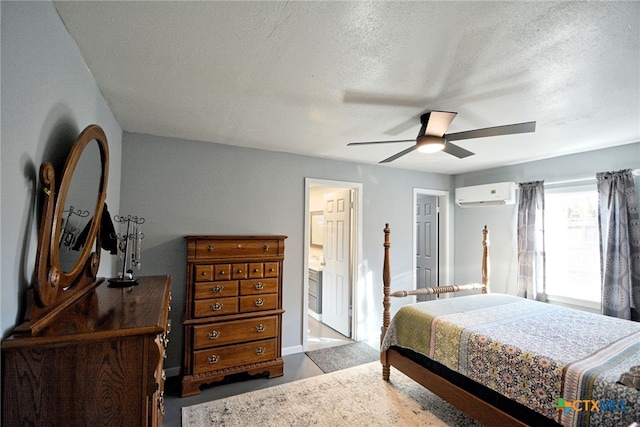 bedroom featuring ensuite bathroom, a wall mounted AC, a textured ceiling, and ceiling fan