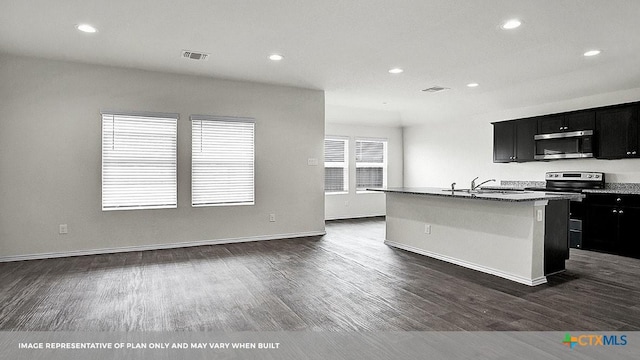 kitchen with dark wood-type flooring, a center island with sink, stainless steel appliances, and sink