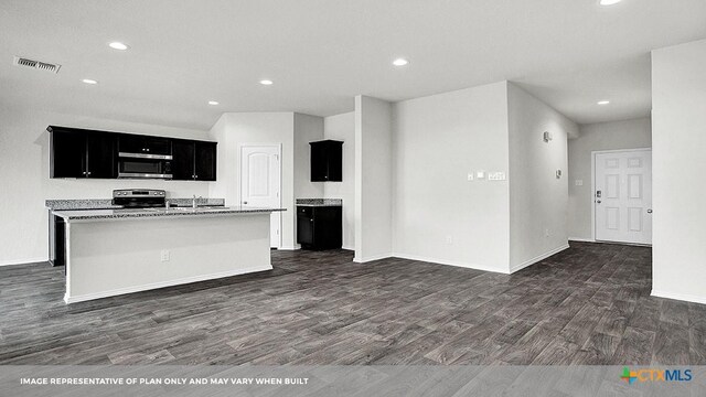 kitchen featuring dark hardwood / wood-style floors, stainless steel appliances, and a kitchen island with sink