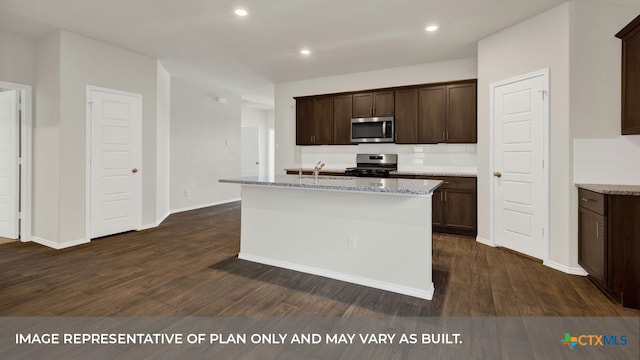 kitchen with appliances with stainless steel finishes, dark hardwood / wood-style floors, and a center island with sink