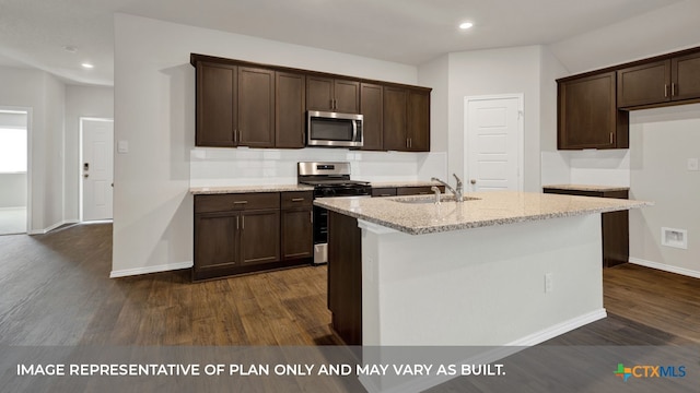 kitchen with light stone counters, stainless steel appliances, a kitchen island with sink, and sink