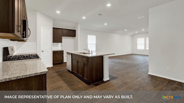 kitchen featuring stainless steel appliances, an island with sink, sink, and light stone counters