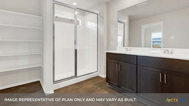 bathroom featuring wood-type flooring, an enclosed shower, and vanity