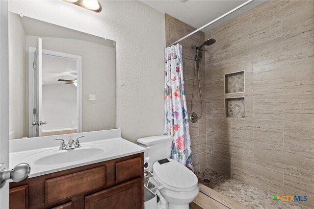6203 Morganite Dr, Killeen, TX 76542 - bathroom featuring tiled shower, vanity, toilet, and ceiling fan