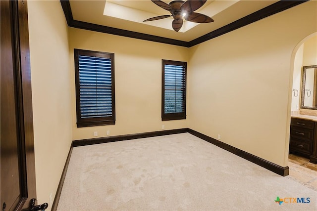 empty room with ornamental molding, light colored carpet, and ceiling fan