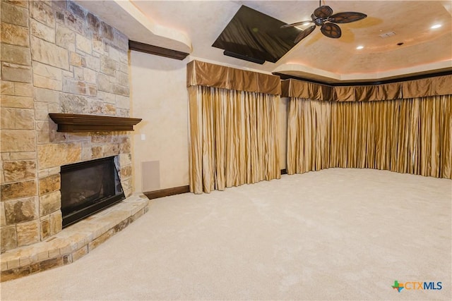 basement featuring ceiling fan, a fireplace, and carpet floors