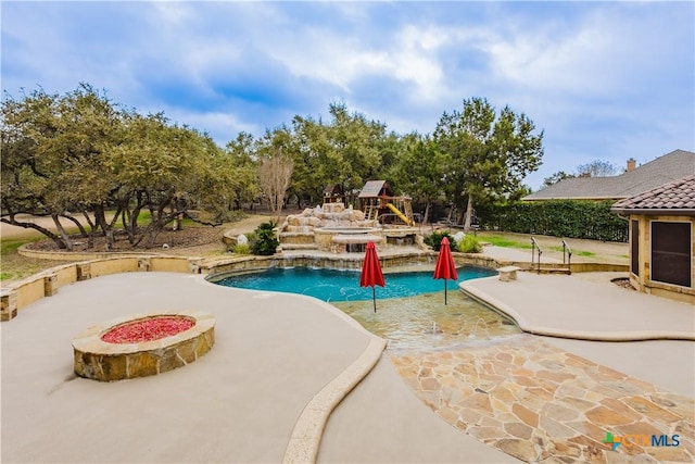 view of swimming pool featuring a fire pit and a patio