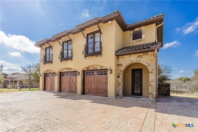 mediterranean / spanish house featuring a garage and a balcony