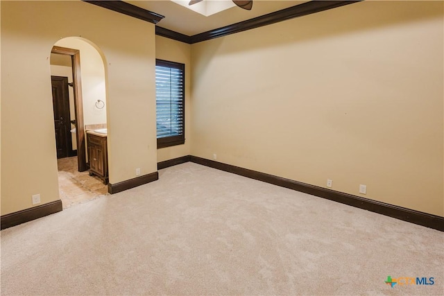 unfurnished bedroom with light carpet, crown molding, ensuite bath, and ceiling fan