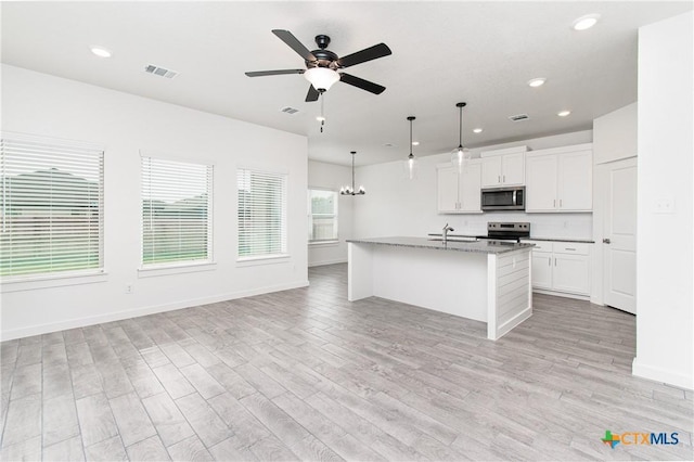 kitchen with light wood-type flooring, white cabinetry, a kitchen island with sink, and appliances with stainless steel finishes