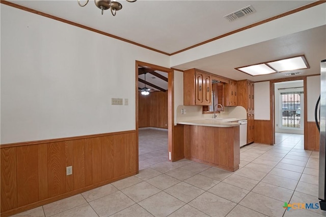 kitchen featuring kitchen peninsula, light tile patterned flooring, dishwasher, crown molding, and sink