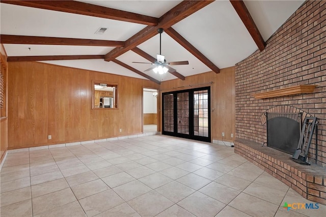 unfurnished living room with french doors, wooden walls, vaulted ceiling with beams, ceiling fan, and light tile patterned floors