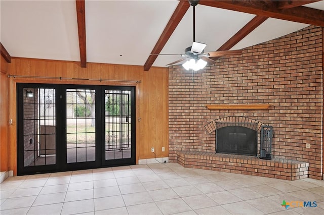 unfurnished living room featuring light tile patterned flooring, a fireplace, wooden walls, and lofted ceiling with beams