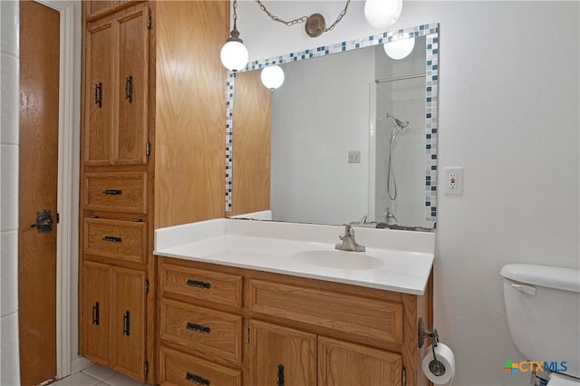 bathroom with toilet, vanity, a shower, and tile patterned floors