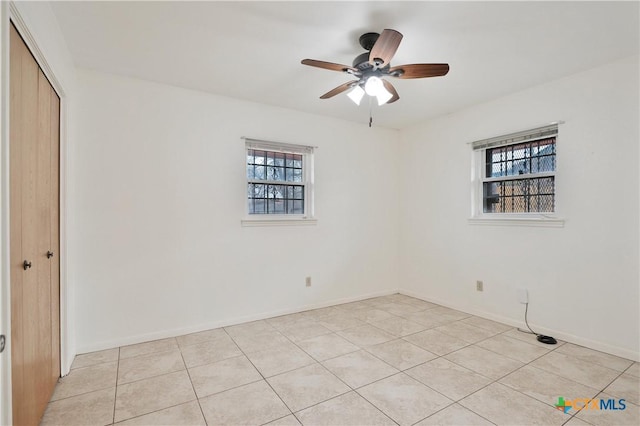 tiled spare room featuring ceiling fan