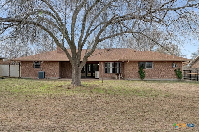 back of property with a lawn and central AC