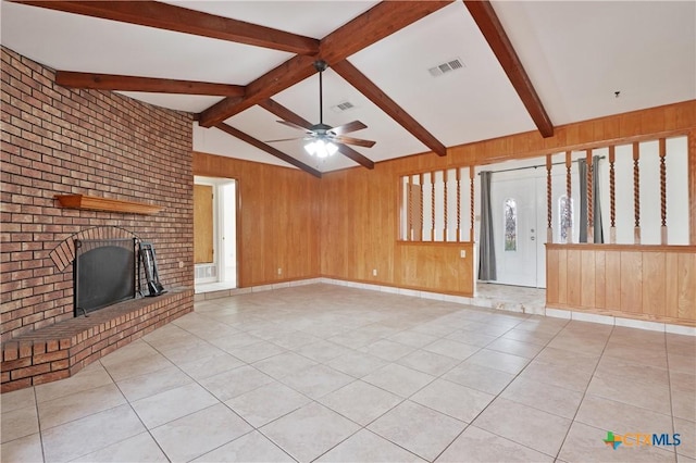 unfurnished living room with light tile patterned floors, a fireplace, wooden walls, and lofted ceiling with beams