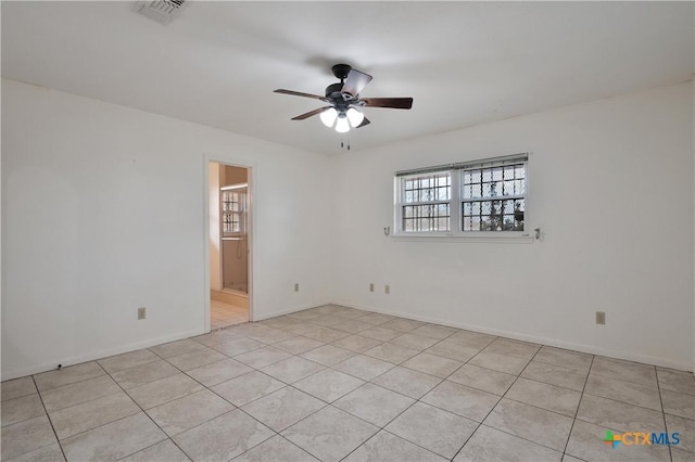 spare room with ceiling fan and light tile patterned floors