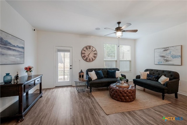 living room featuring ceiling fan, a healthy amount of sunlight, and wood-type flooring