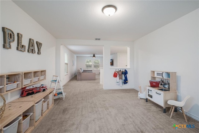 rec room featuring ceiling fan and light colored carpet