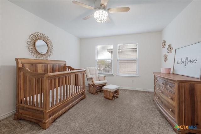 bedroom featuring ceiling fan, a nursery area, and light carpet